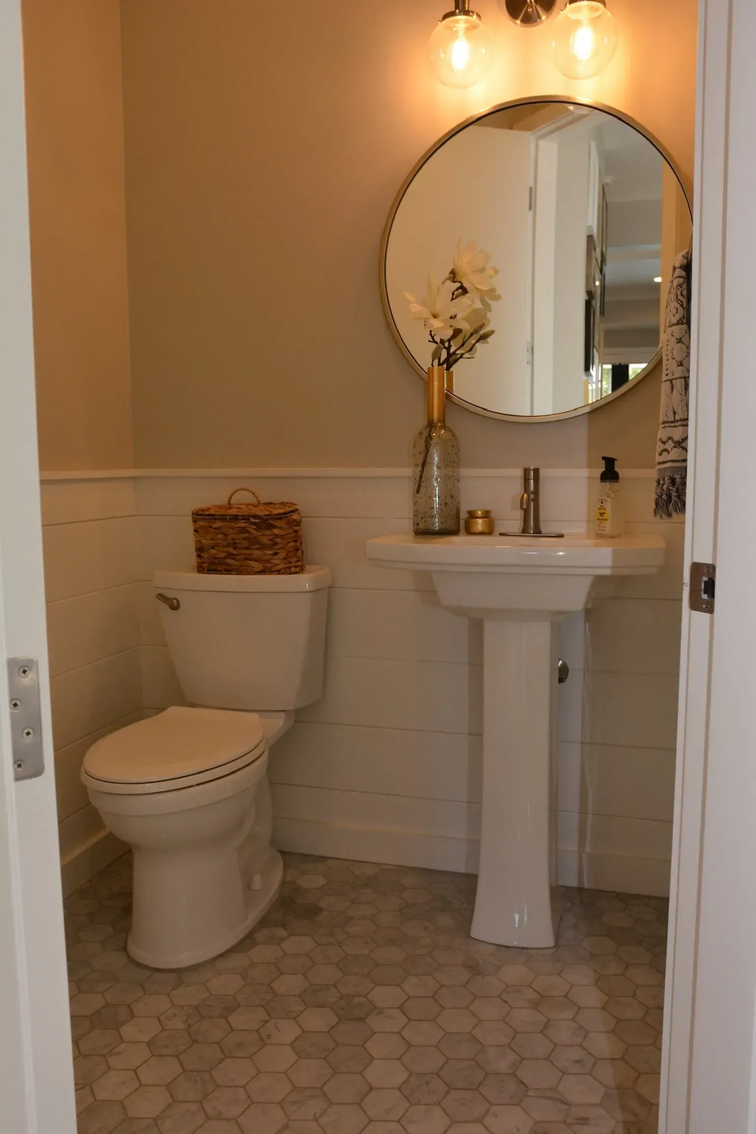 A bathroom with a toilet , sink and mirror.
