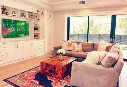 A living room with a couch , coffee table , and television.