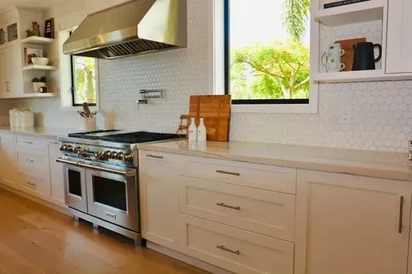 A kitchen with stainless steel appliances and white cabinets