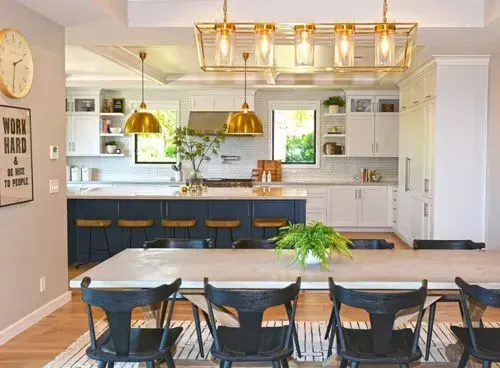 A kitchen with a table and chairs and a clock on the wall.