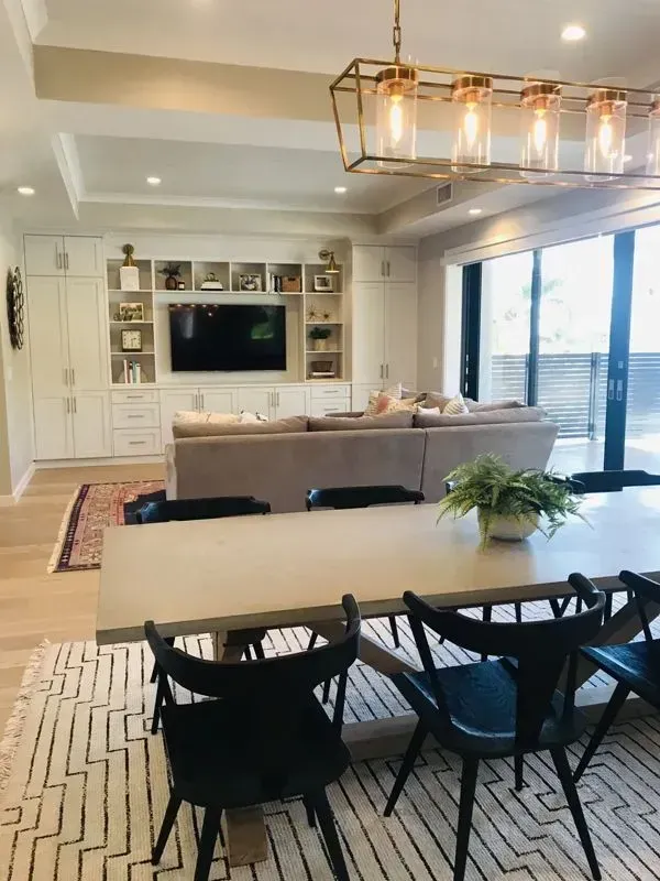 A living room with a dining table and chairs and a television.
