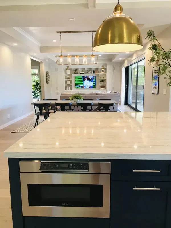 A kitchen with a large island and a microwave oven.