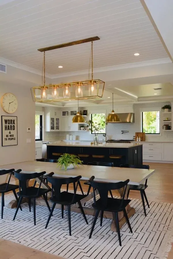 A kitchen with a table and chairs and a clock on the wall