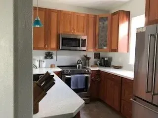 A kitchen with stainless steel appliances and wooden cabinets.