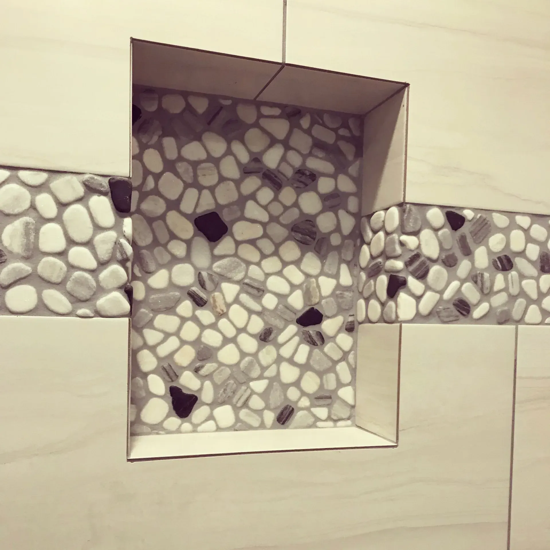 A tiled wall with a niche in the middle of it