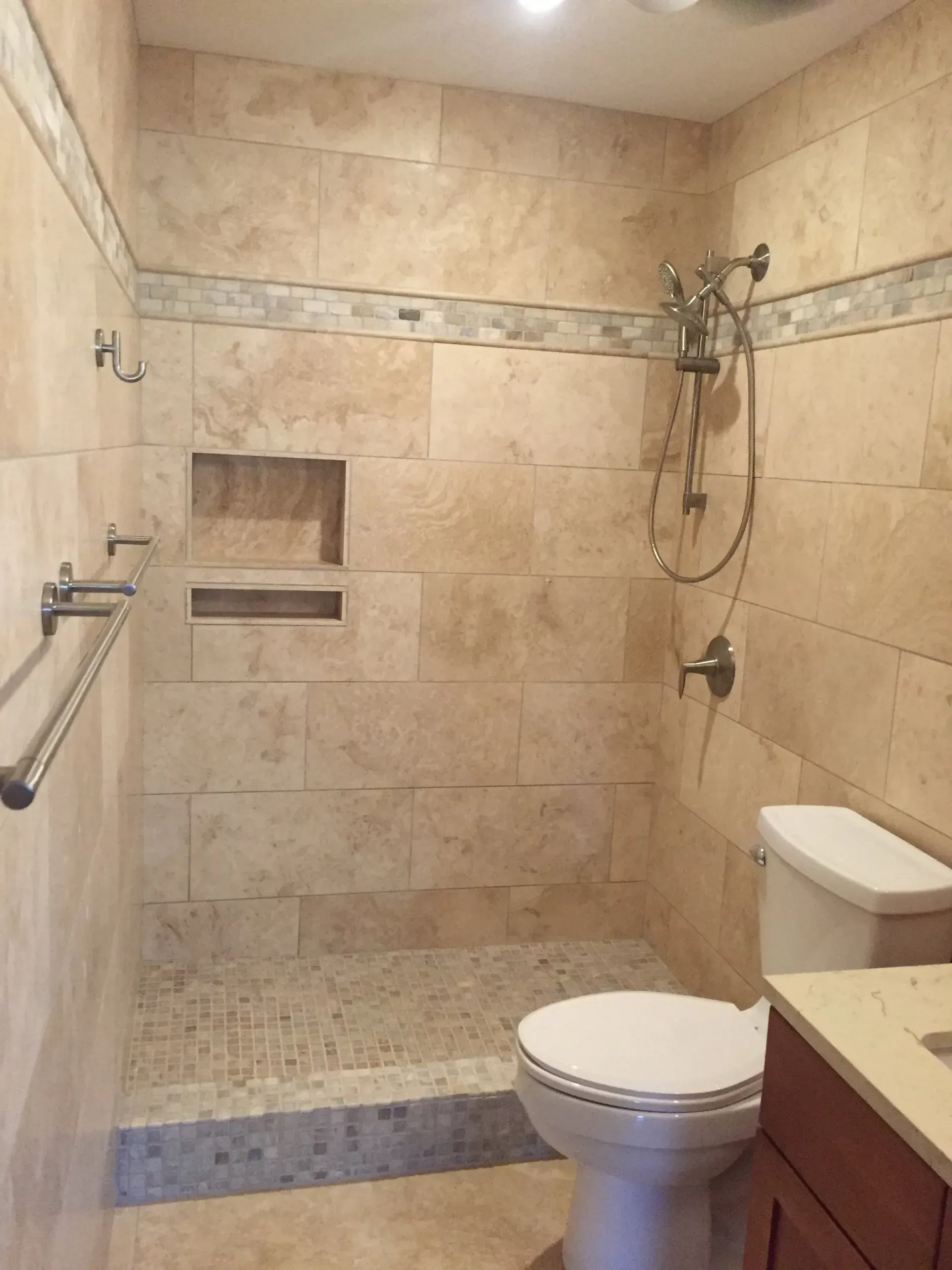 An empty room with a ladder , paint roller , and bucket of paint.