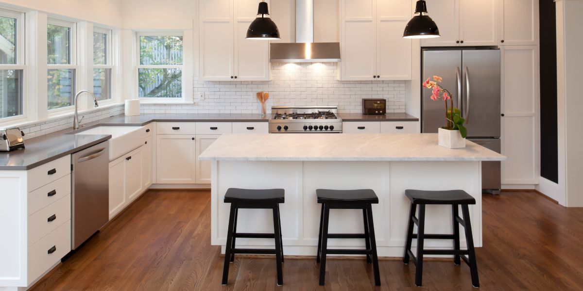 A group of men are working on a kitchen in a house.