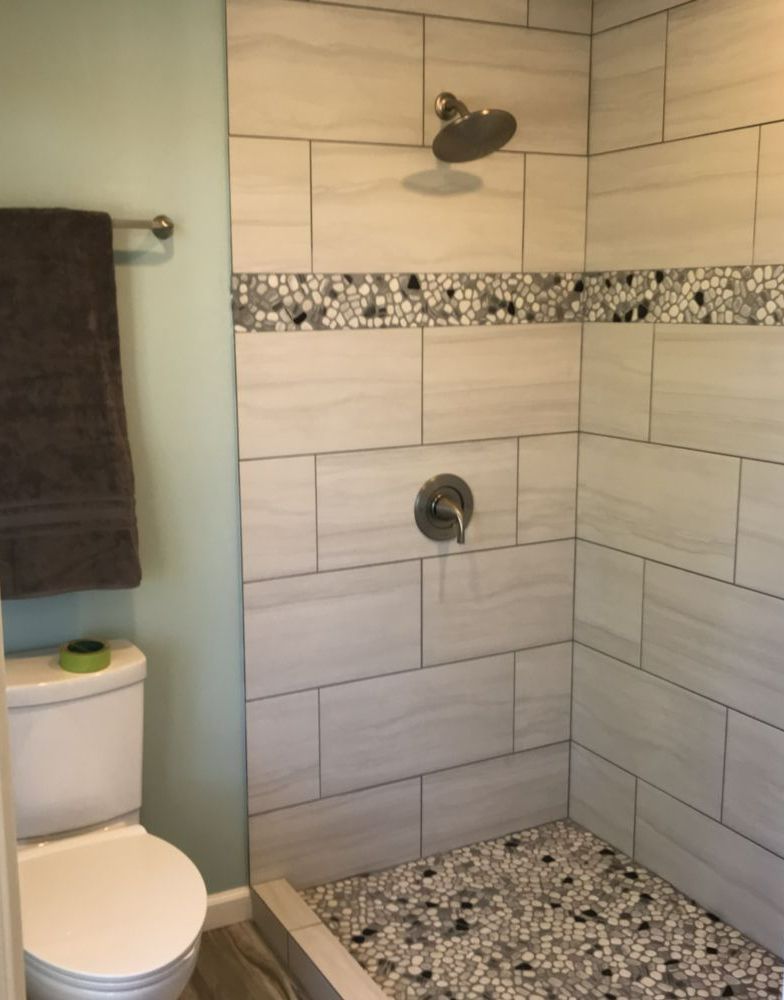 An empty room with a ladder , paint roller , and bucket of paint.