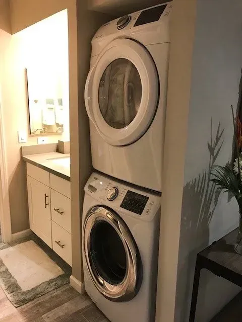 A washer and dryer are stacked on top of each other in a laundry room.