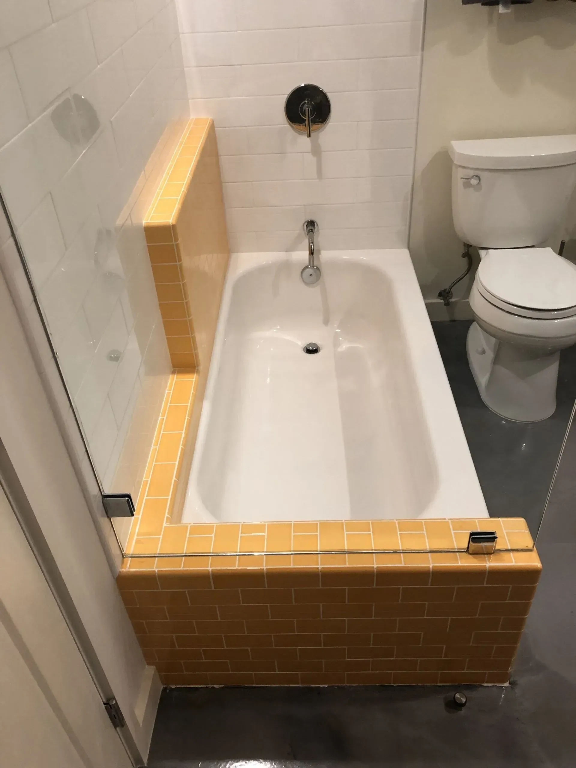 A bathtub in a bathroom next to a toilet