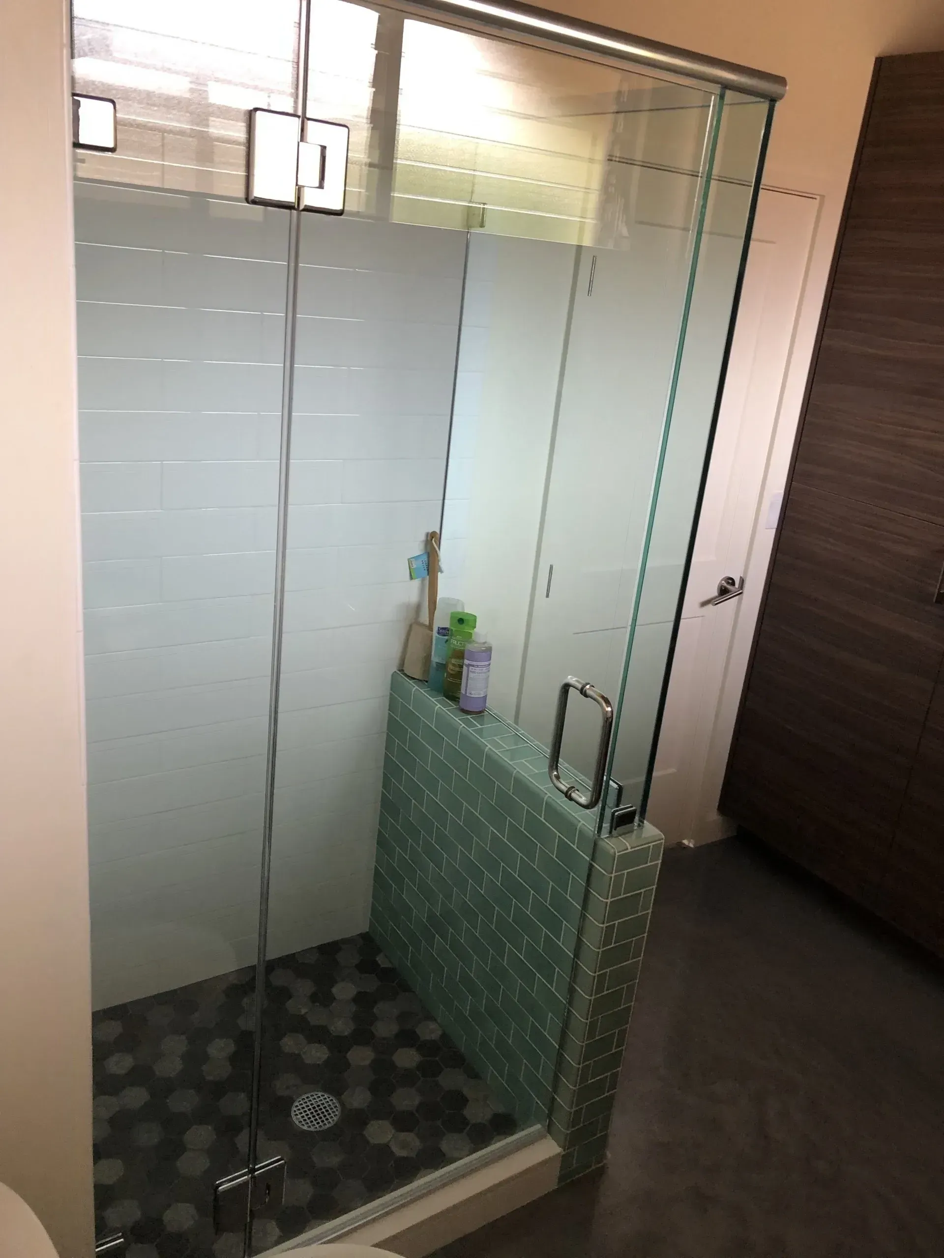 A bathroom with a sliding glass shower door and a toilet.