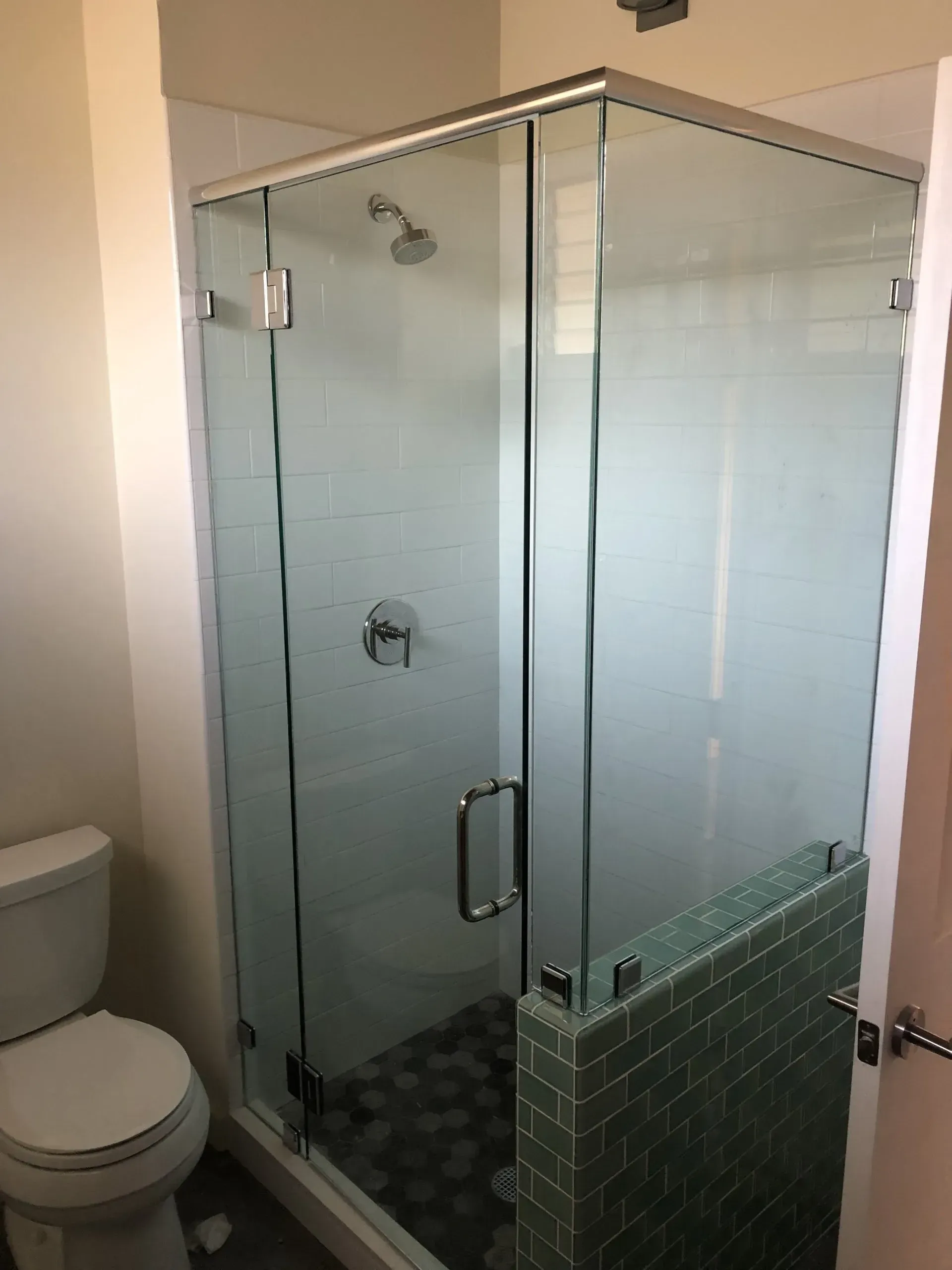 A bathroom with a toilet and a shower stall