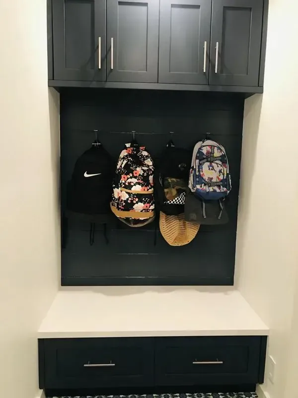 A shelf with backpacks and hats hanging on it.