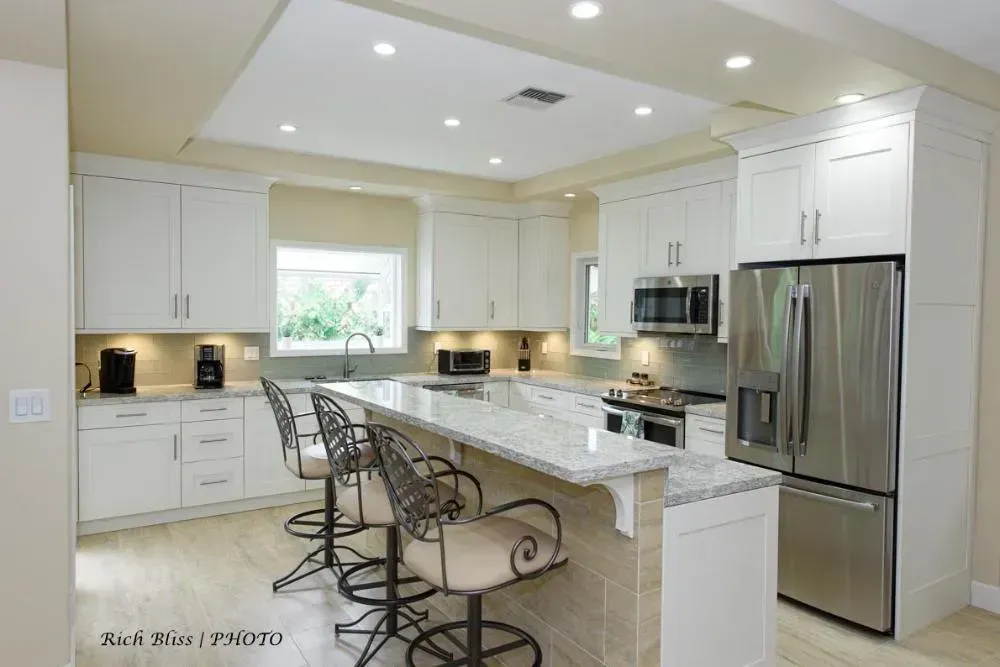 A kitchen with white cabinets and stainless steel appliances