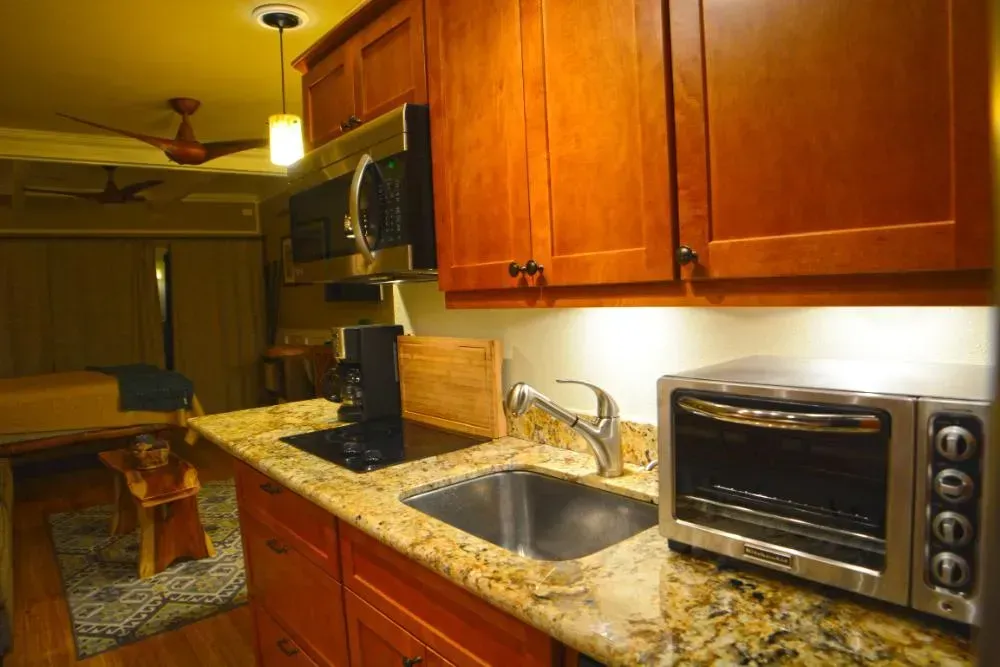 A kitchen with a sink , microwave , and toaster oven.