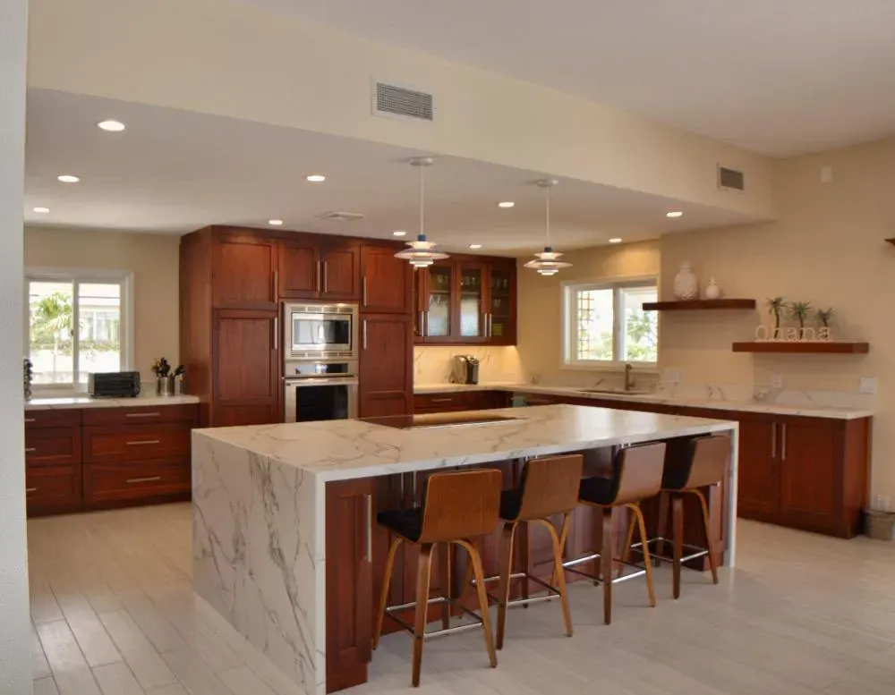 A kitchen with marble counter tops and wooden cabinets