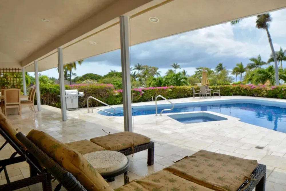 There is a large swimming pool in the backyard of a house.