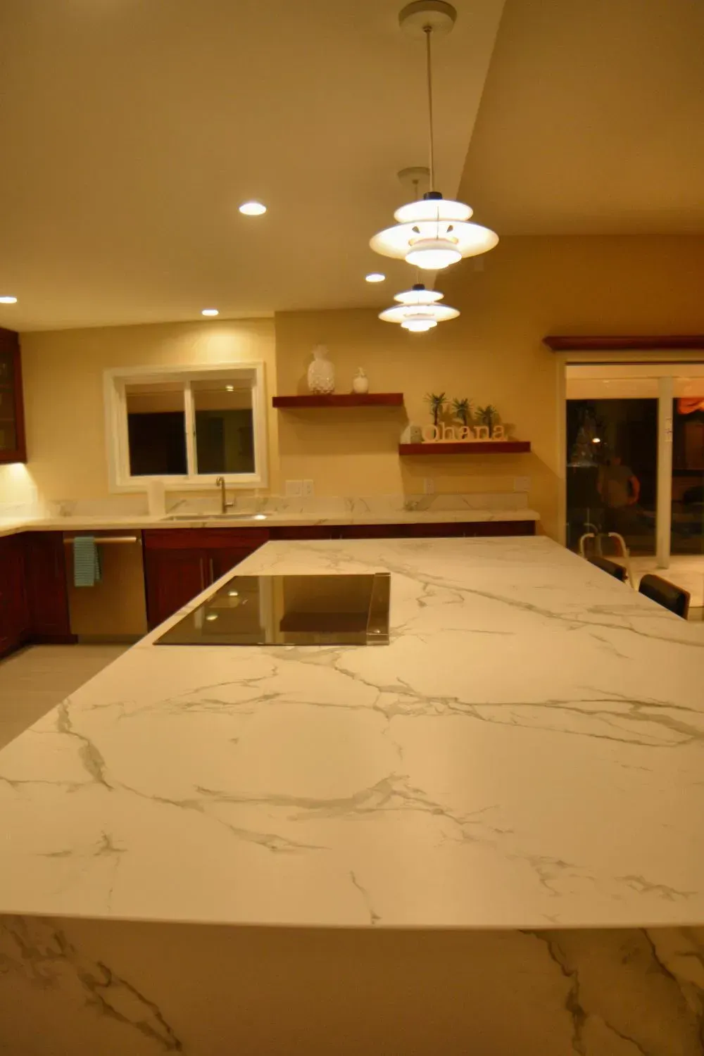 A kitchen with a marble counter top and a stove top oven