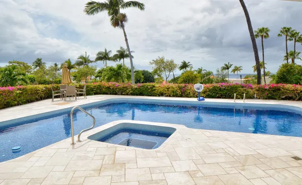 There is a large swimming pool with a hot tub in the middle of it.