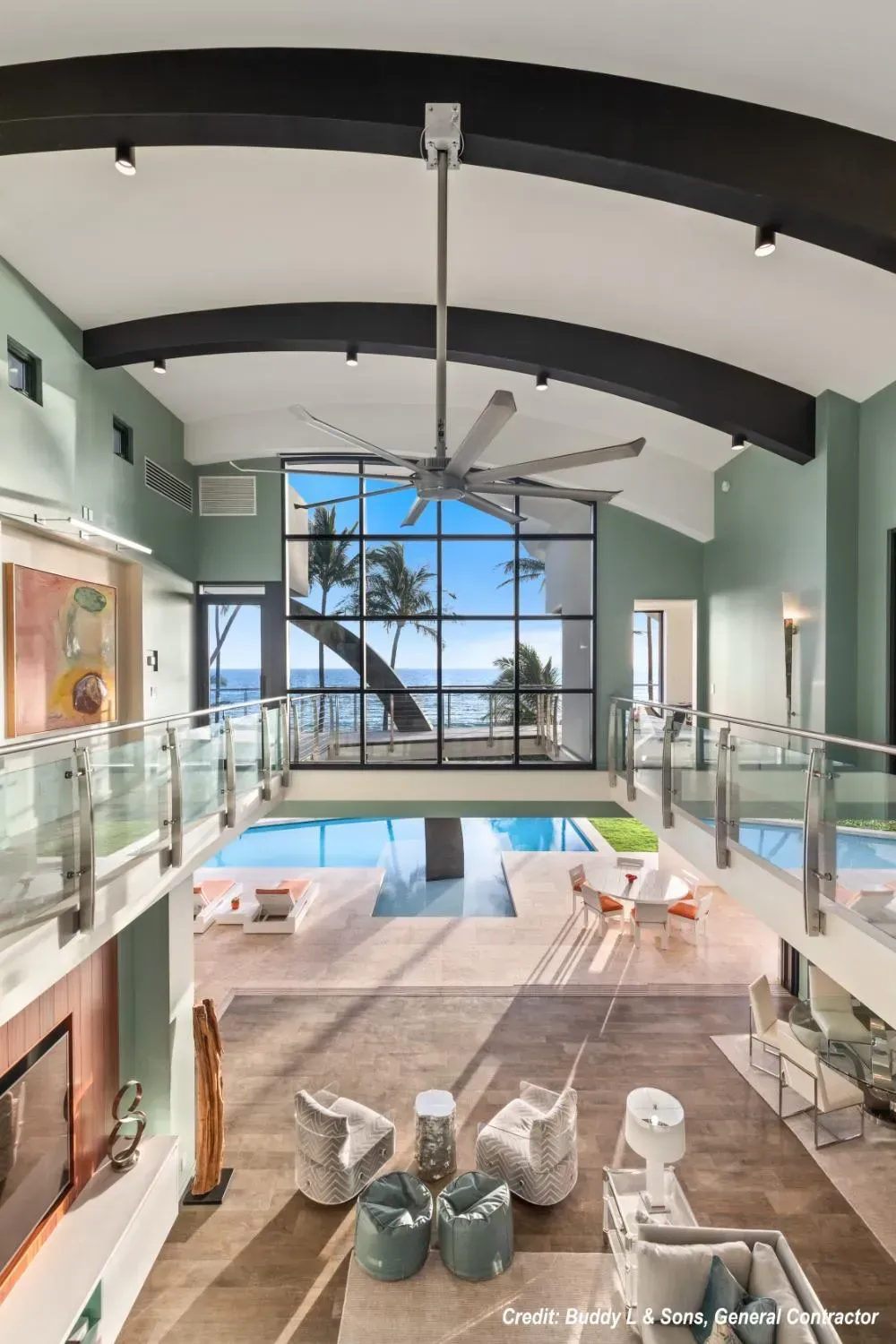 A large living room with a ceiling fan and a swimming pool.