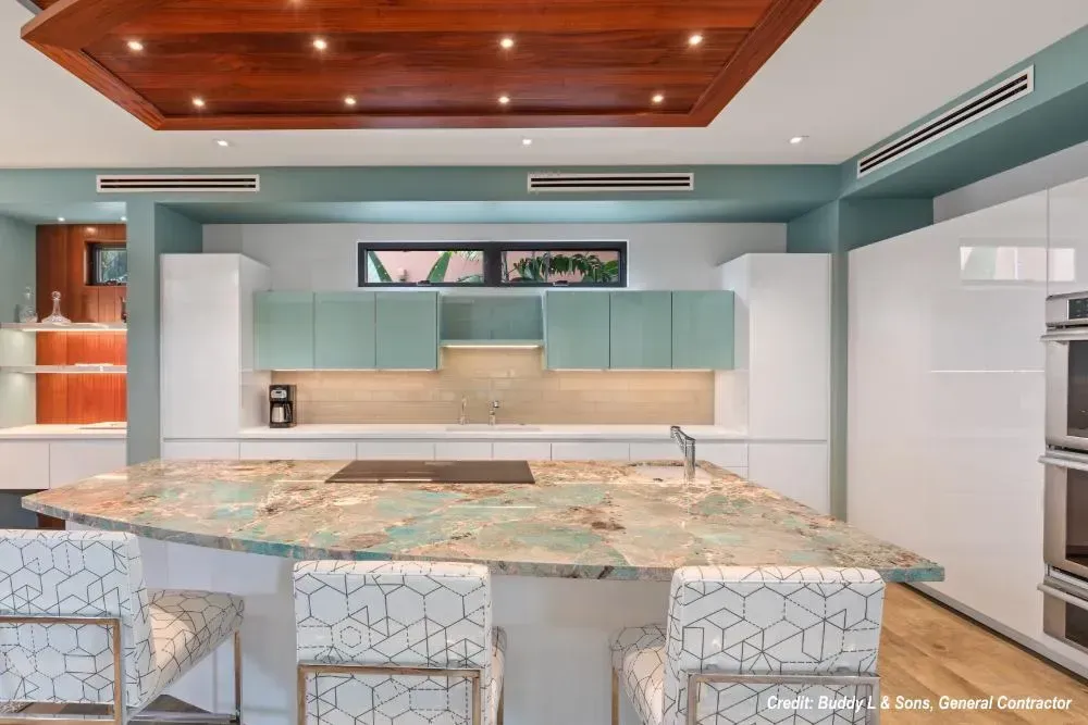 A kitchen with a large island and white cabinets