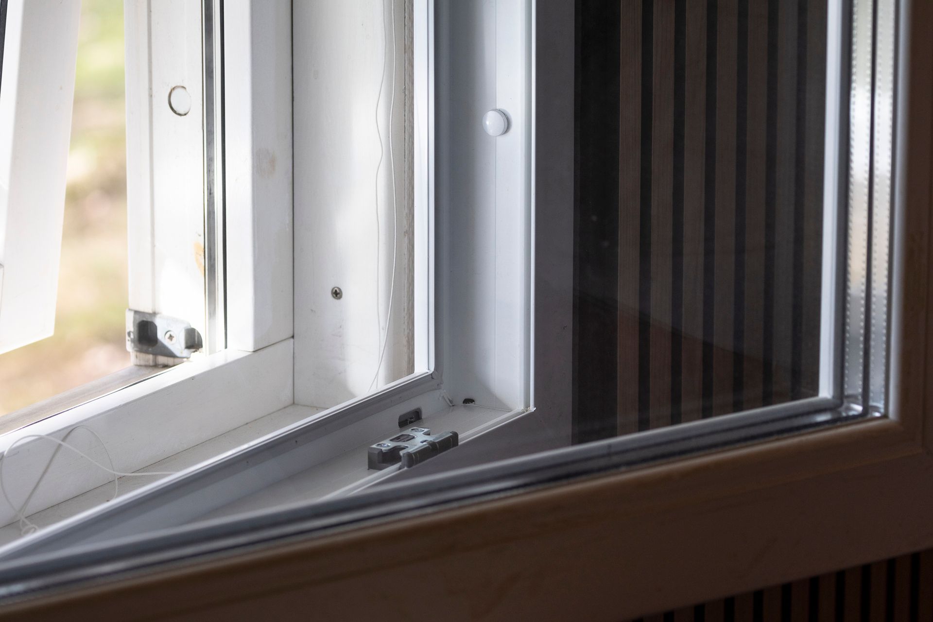 Open white casement window, interior view. Window frame and glass are visible.