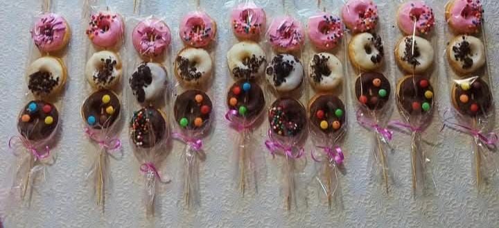 Mini brochetas de donuts con glaseado rosa, chispas y cobertura de chocolate.