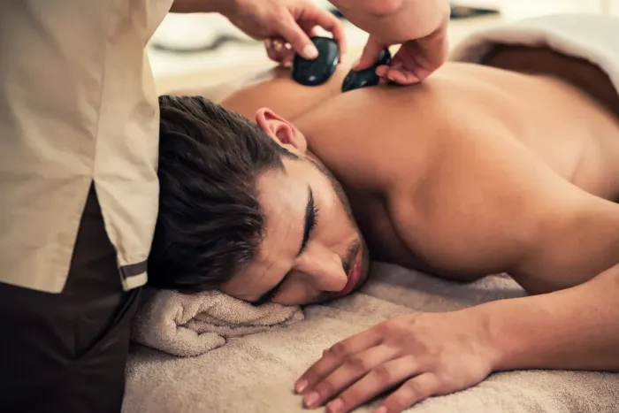 A man is getting a hot stone massage at a spa.