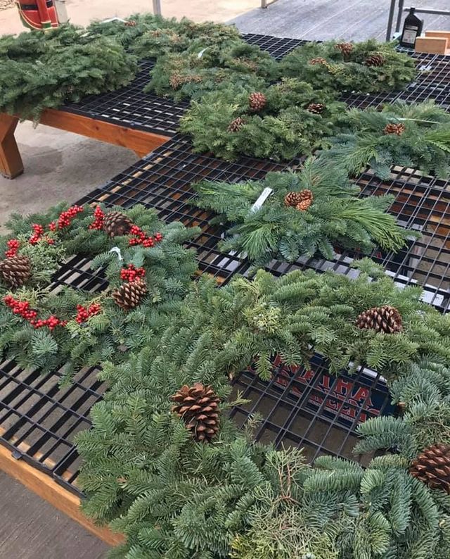 A Bunch of Christmas Wreaths Are Sitting on A Table | Bentonville, AR | Bogle's Garden City