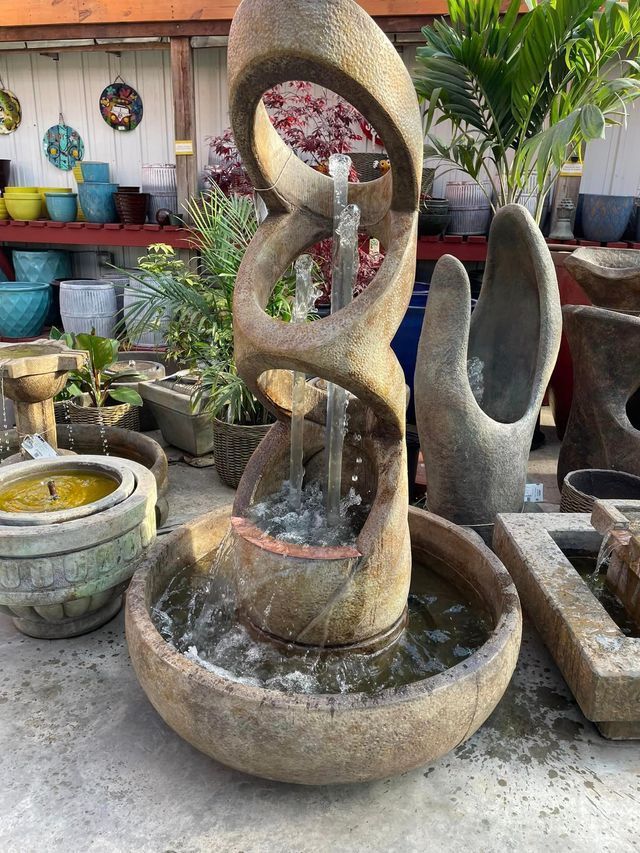 A Fountain Is Sitting on The Ground in A Garden Surrounded by Potted Plants | Bentonville, AR | Bogle's Garden City