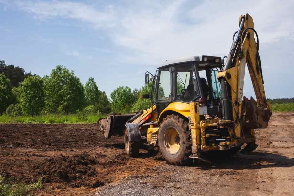 Yellow Excavator Clearing And Leveling Land — Rayment Excavations in Gladstone, QLD