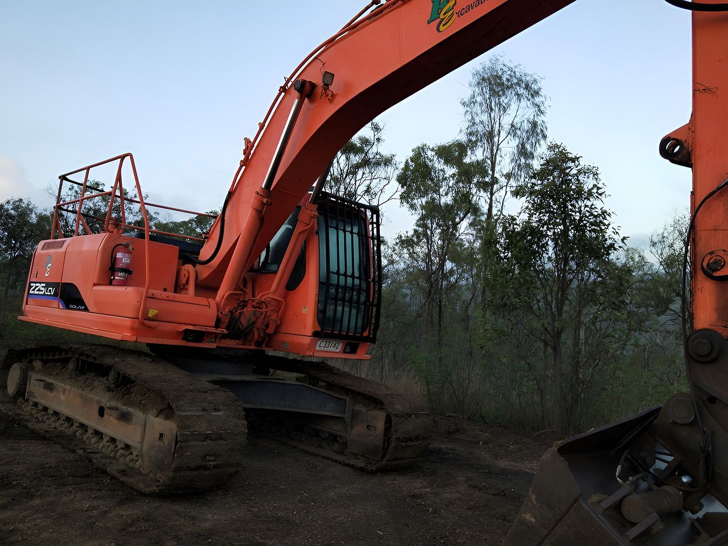 Orange Excavator On A Muddy Dirt Path