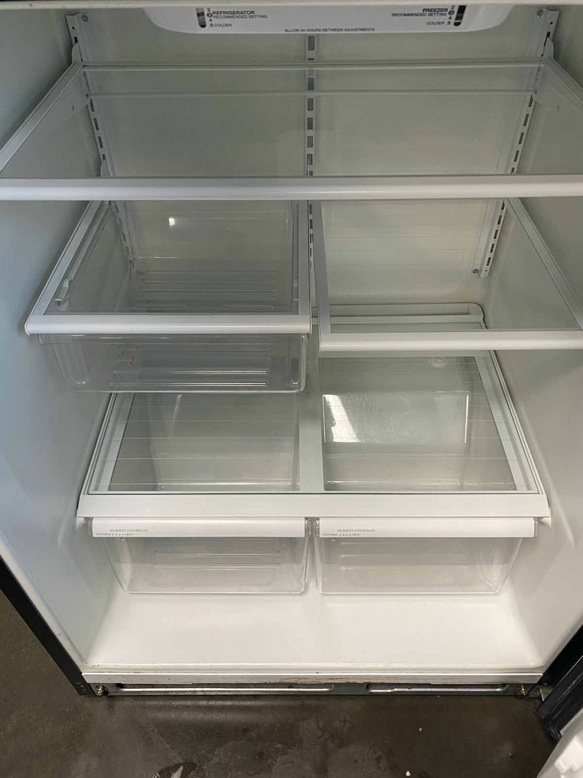 Empty refrigerator interior with clear shelves and drawers.