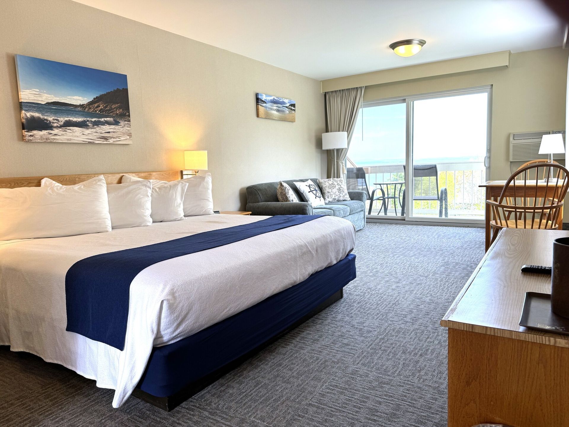 A hotel room with a king size bed and sliding glass doors