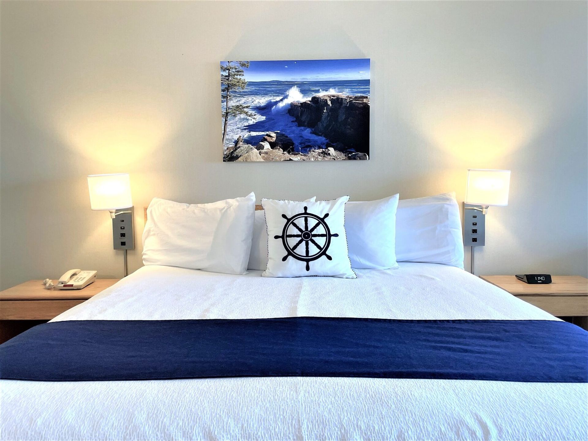 A hotel room with a bed and a picture on the wall above it