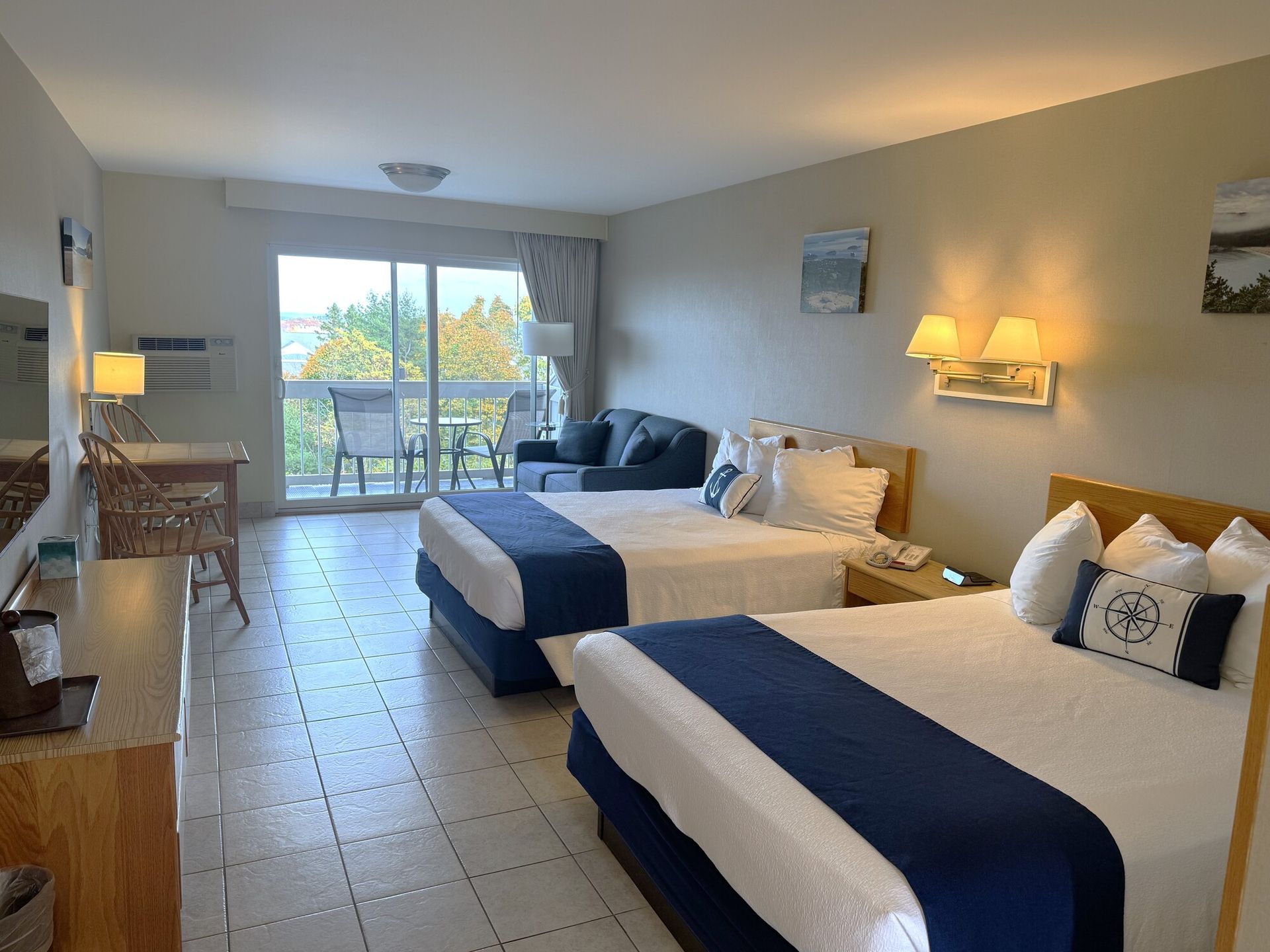 A hotel room with two beds and a balcony