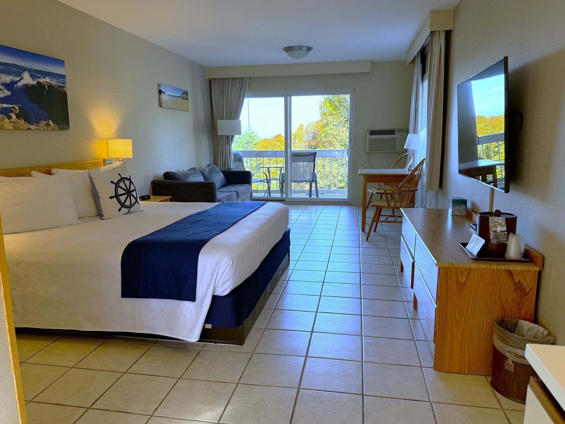 A hotel room with a king size bed and a flat screen tv