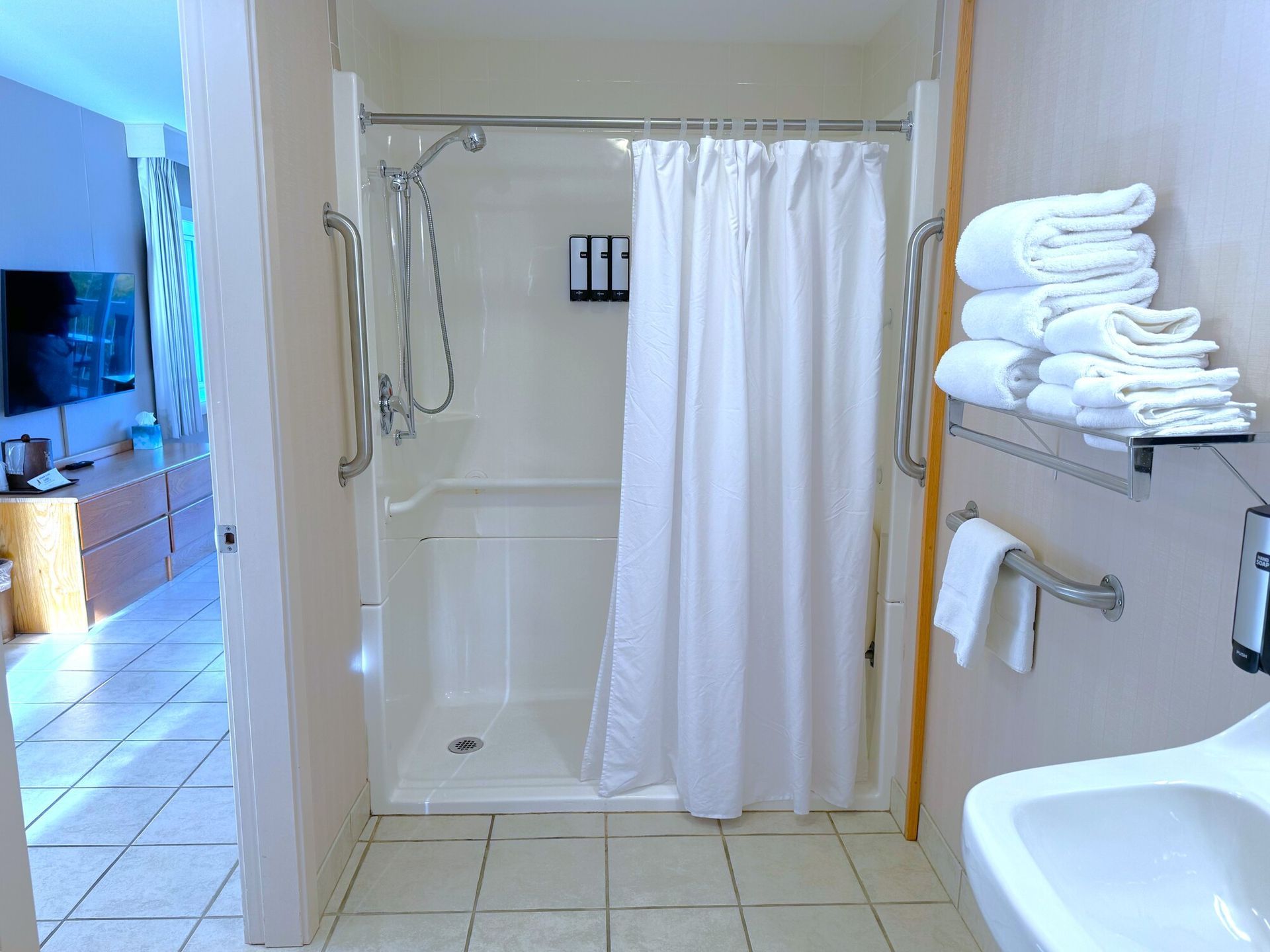 A bathroom with a walk in shower and a sink.