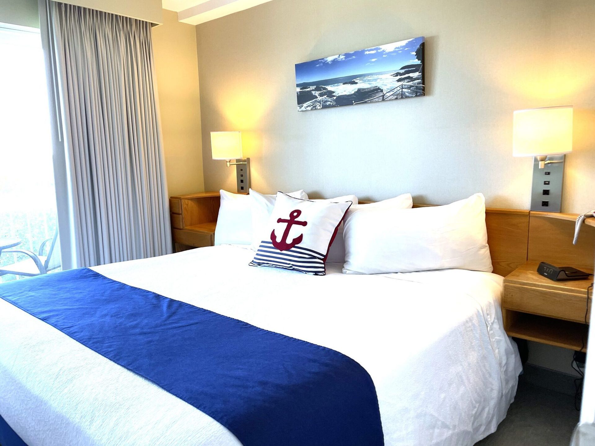 A hotel room with a bed and a picture on the wall