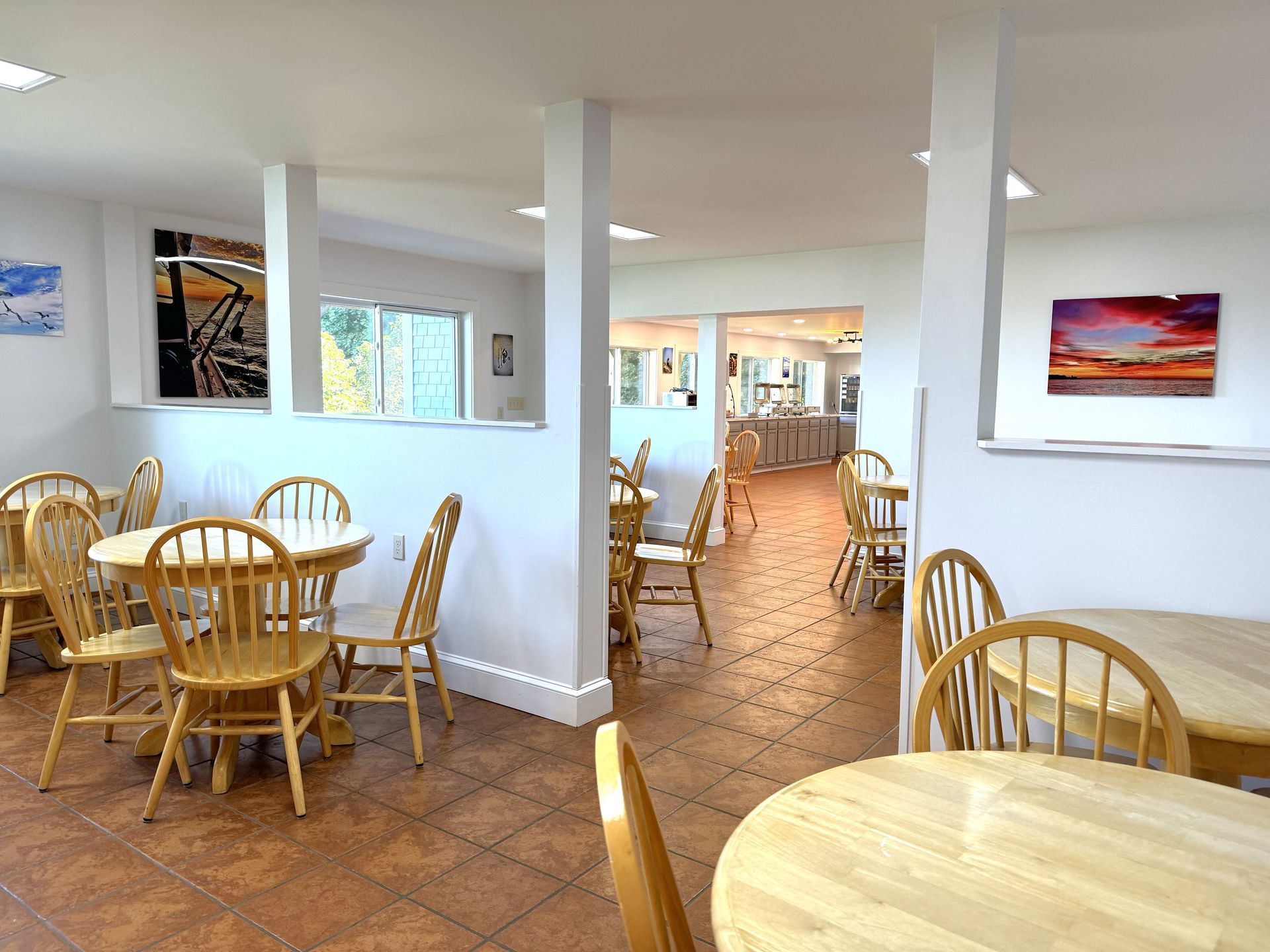 A restaurant with tables and chairs and a painting on the wall
