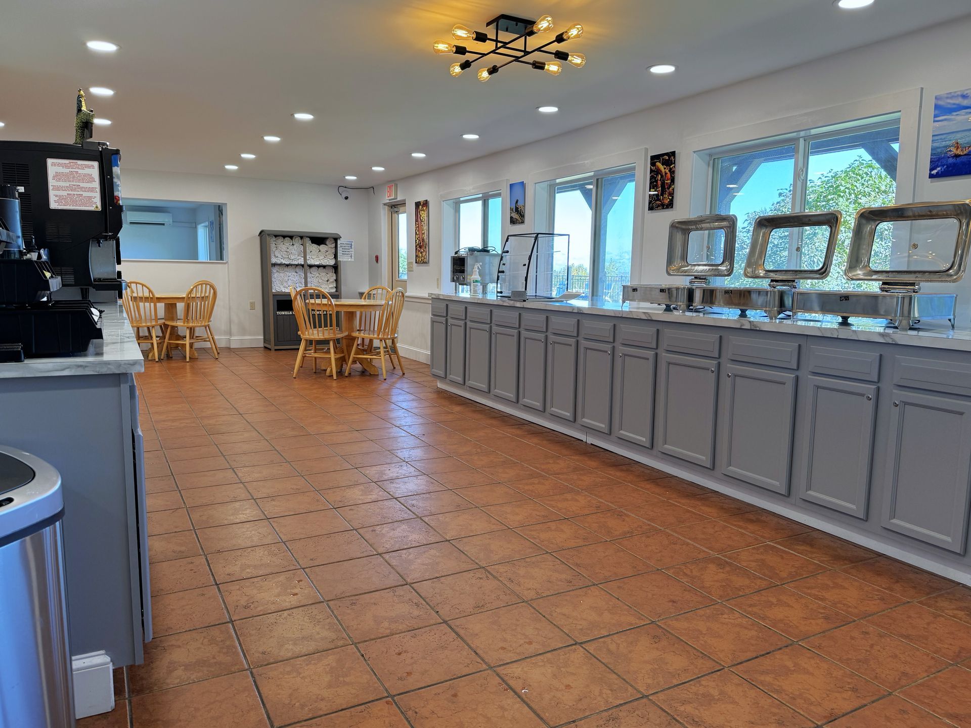 A large room with a buffet line and tables and chairs.