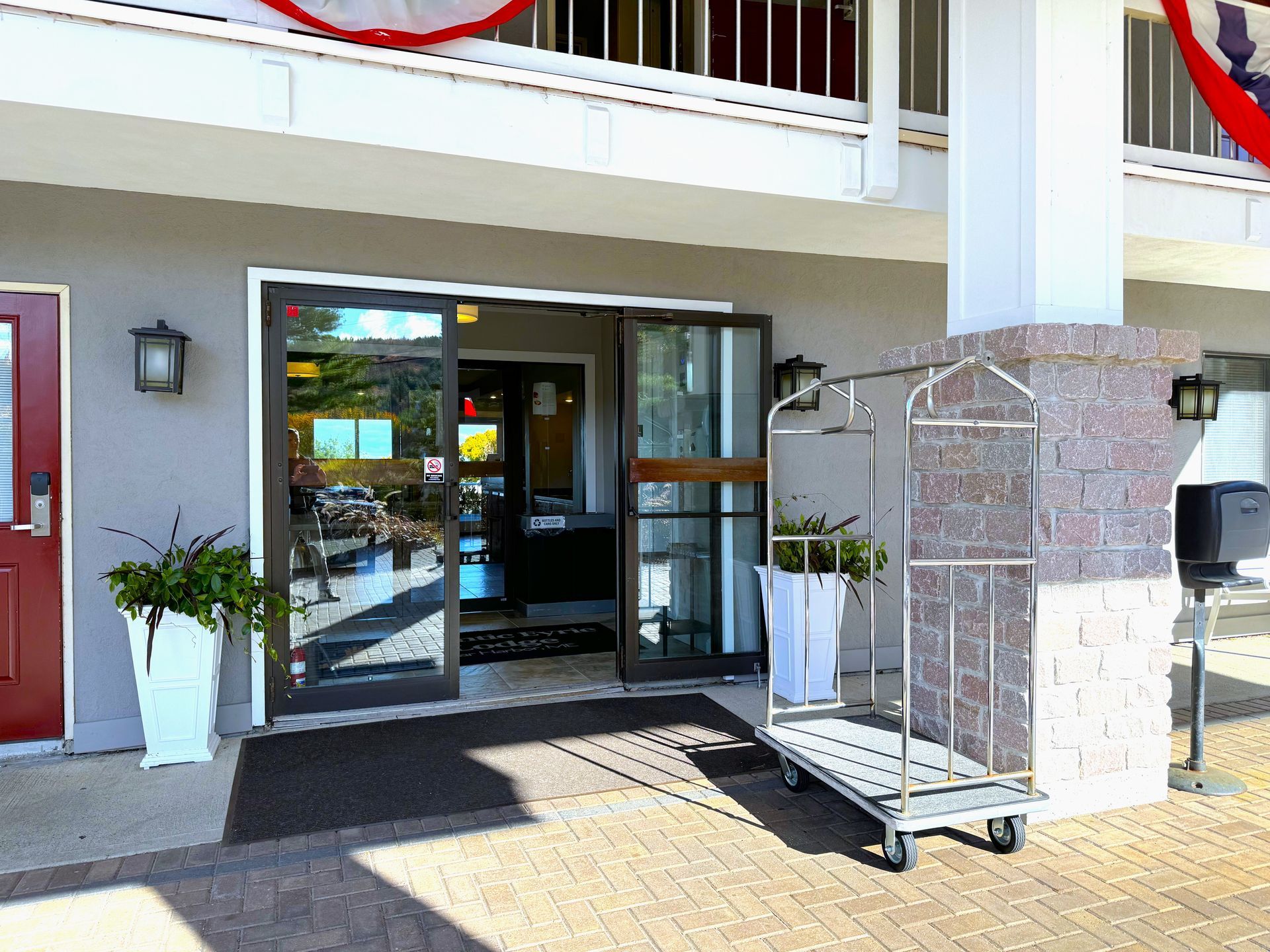 A luggage cart is parked in front of a hotel entrance.