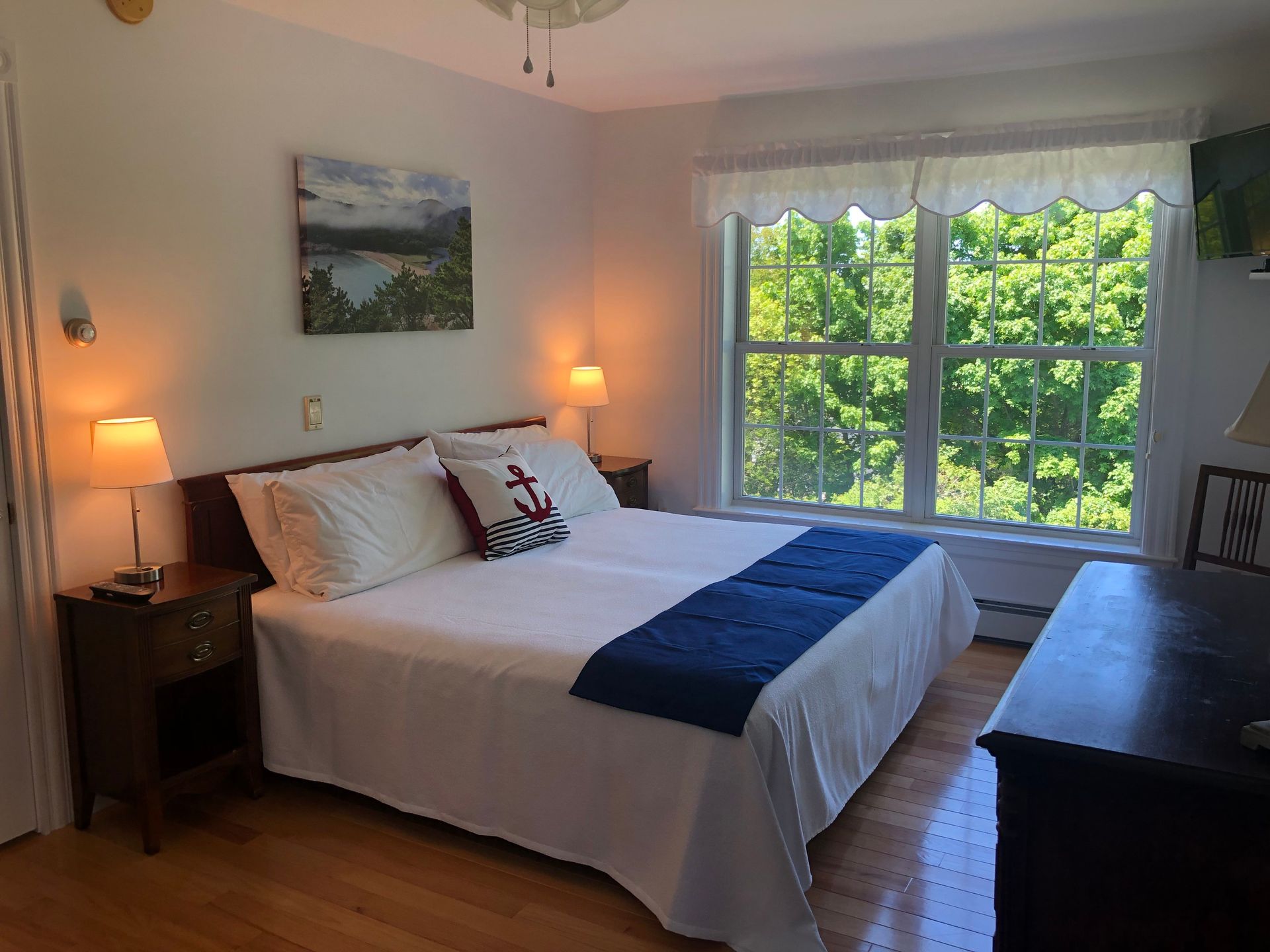 A bedroom with a large bed and two windows