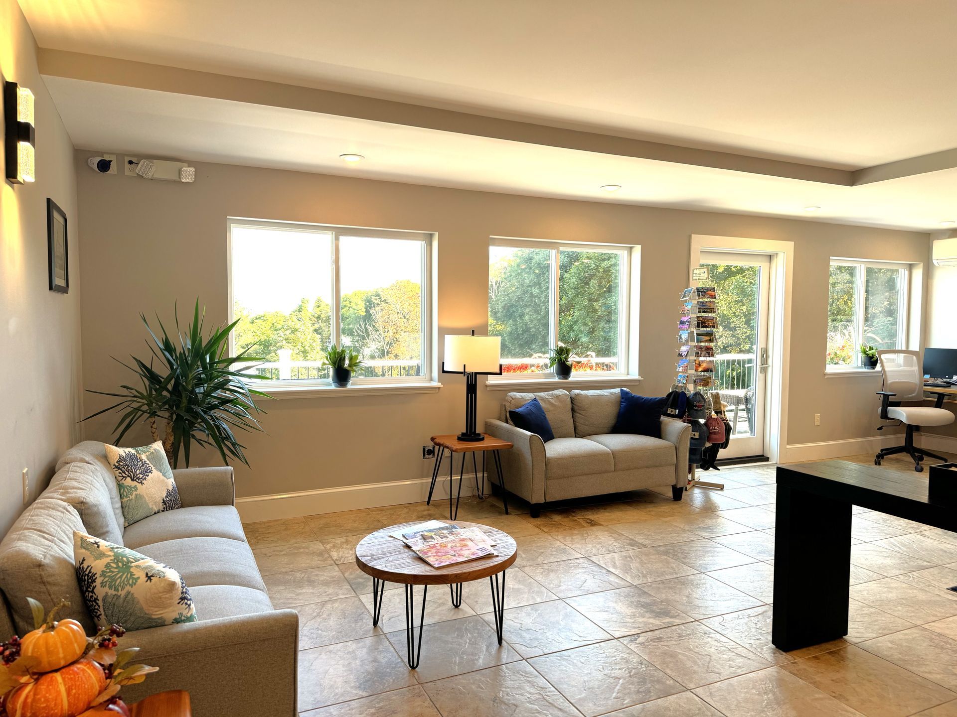 A living room with a couch , table , and many windows.
