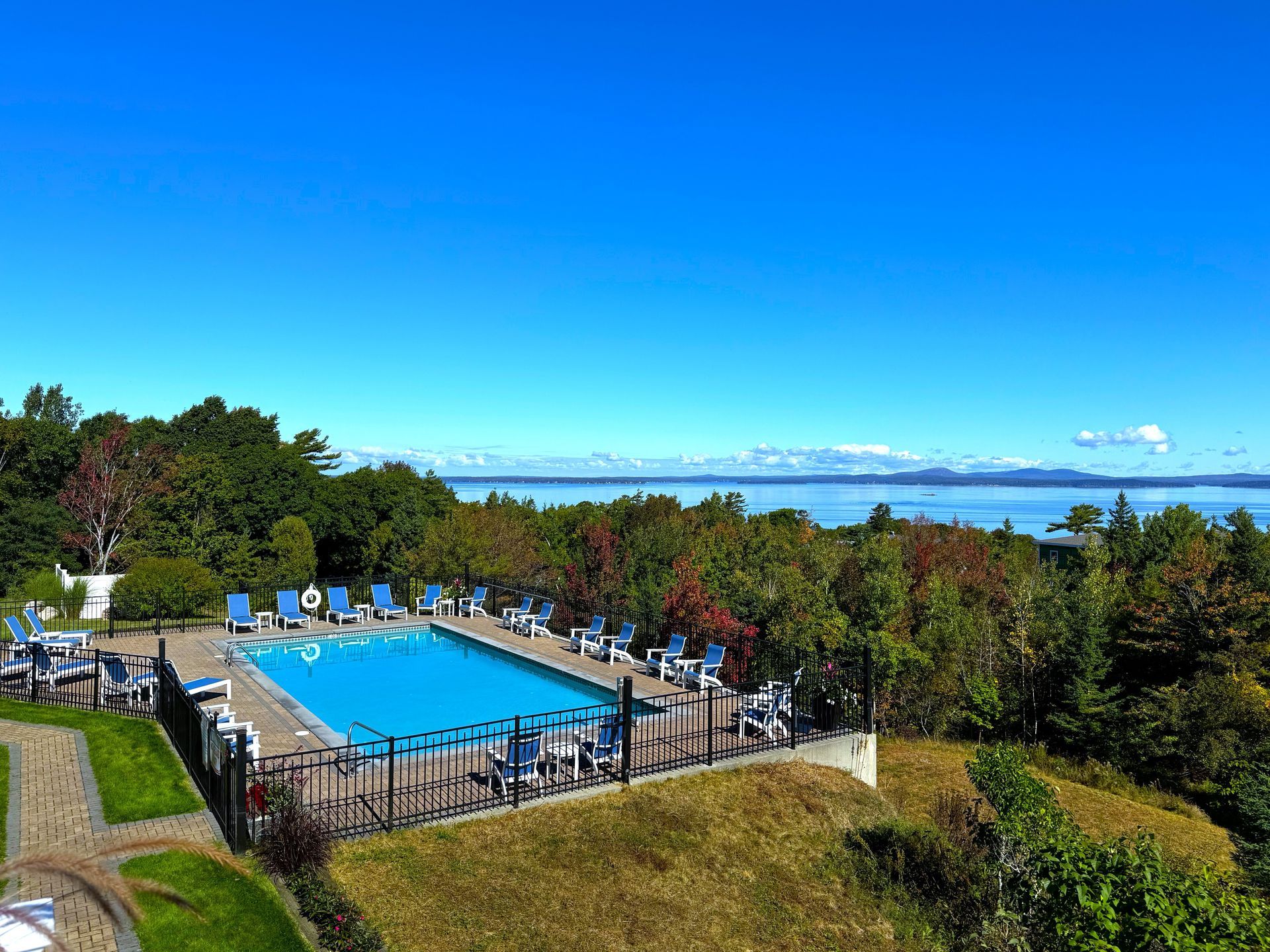 An aerial view of a large swimming pool surrounded by chairs and trees.