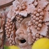 Terracotta mask with grape clusters