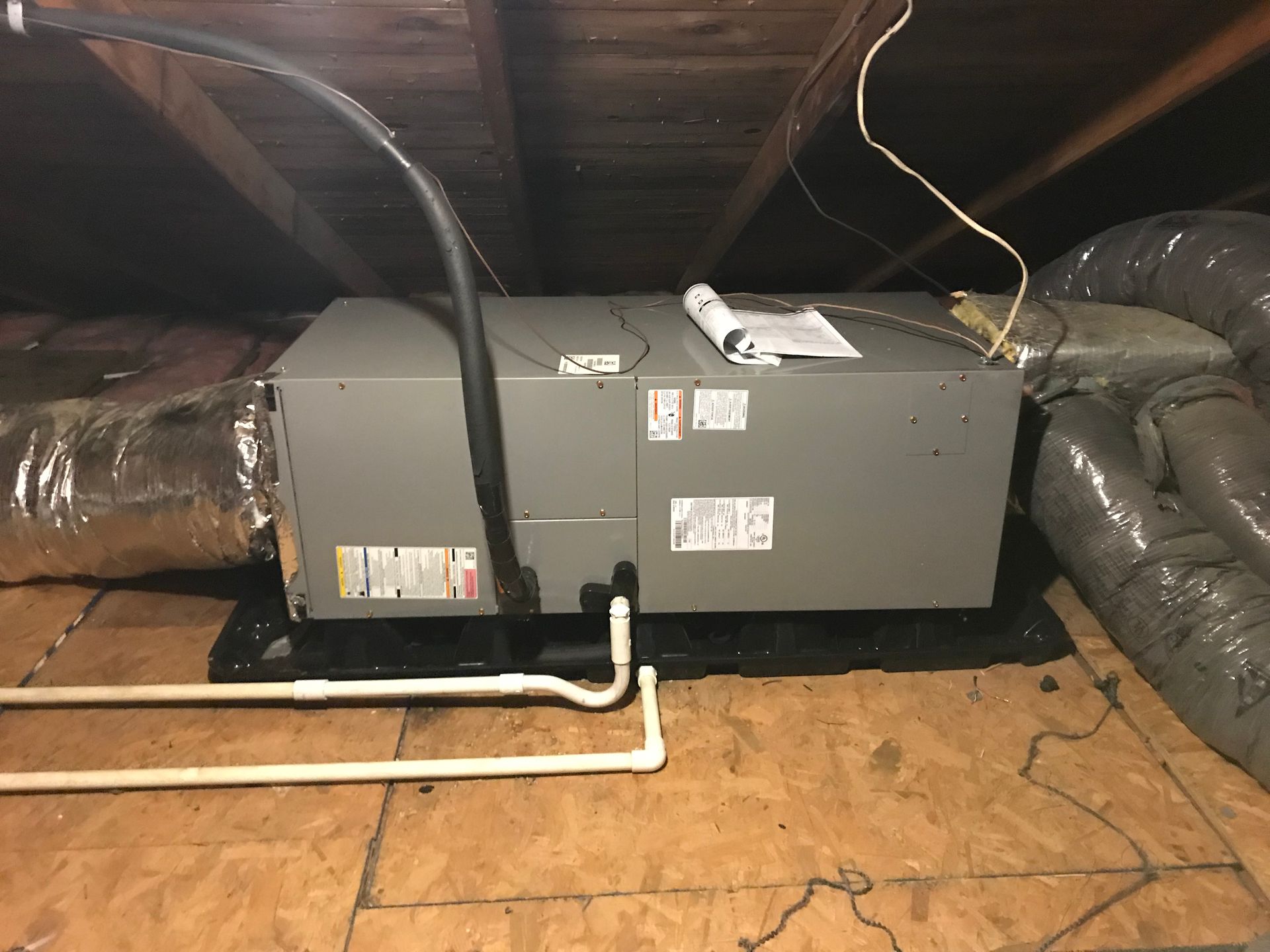 An air conditioner is installed in the attic of a house.