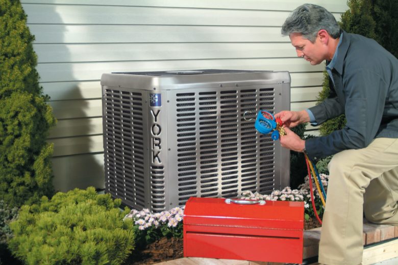 HVAC Tech examining external central ac unit