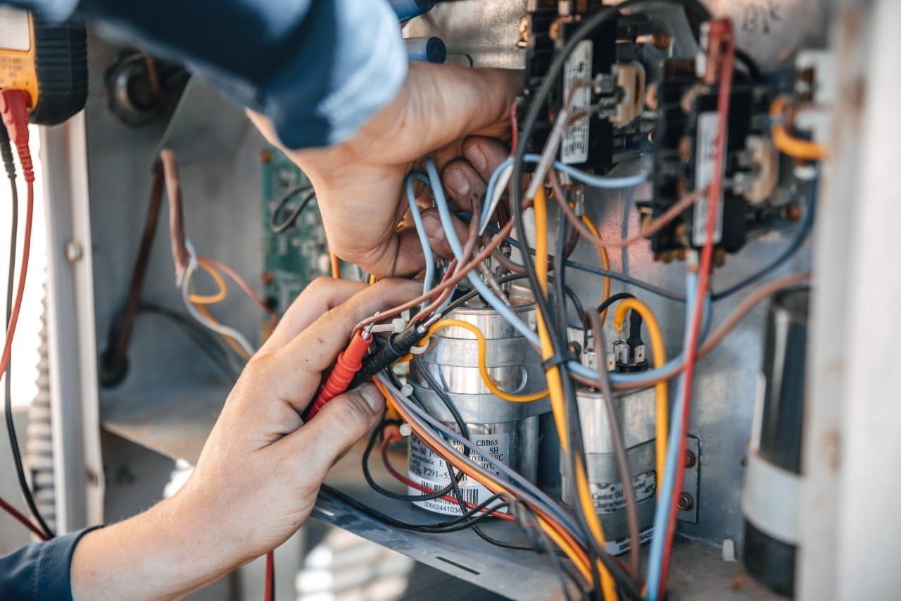 A man is working on an electrical system with a multimeter.