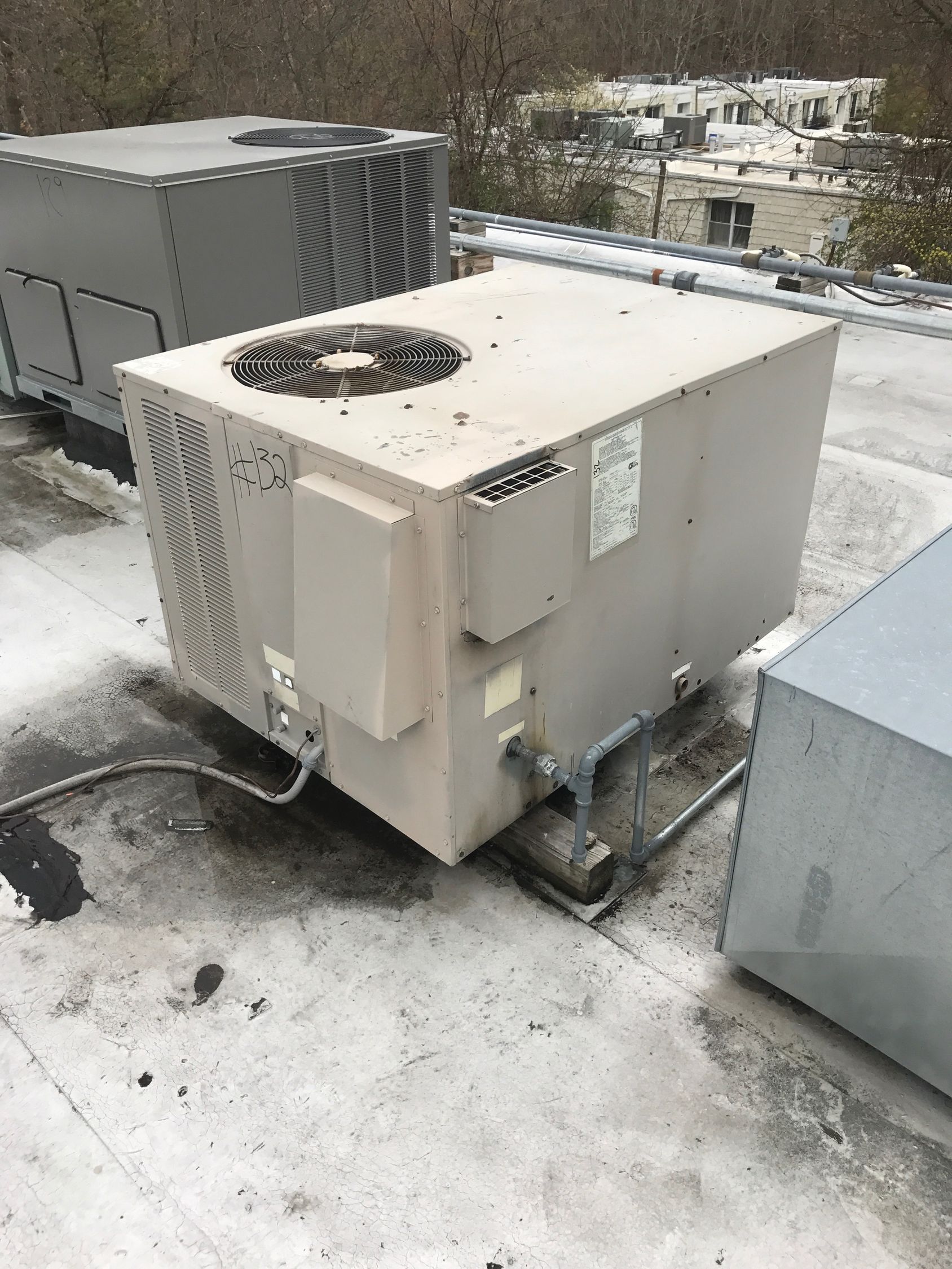 A large air conditioner is sitting on top of a roof.